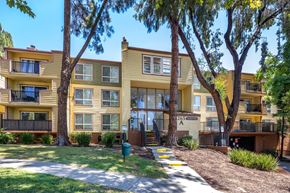 Pleasant Hill apartment for rent - A yellow apartment building with a green trash can in front.