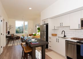 Gresham apartment for rent - Arts Plaza Gresham Oregon Apartments A modern kitchen with a dining table and chairs.