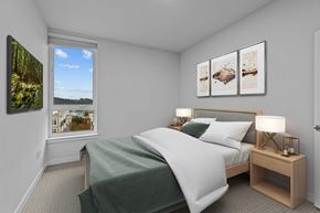 Bainbridge apartment for rent - A bedroom with a large bed and a window overlooking a cityscape.