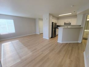 Draper apartment for rent - an empty living room and kitchen with wood flooring
