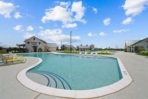 Liberty Hill apartment for rent - a large swimming pool with lounge chairs in front of a building