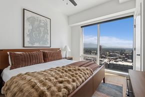 Salt Lake City apartment for rent - A bedroom with a large bed and a view of the city.