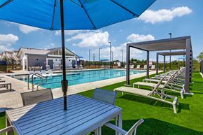 Leander apartment for rent - A poolside table with a blue umbrella over it.