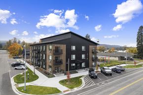 Post Falls apartment for rent - A black building with a parking lot in front of it.