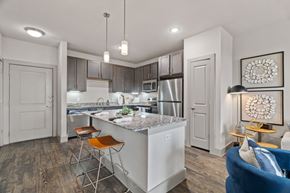 Kyle apartment for rent - A modern kitchen with a bar stool and a blue sofa.