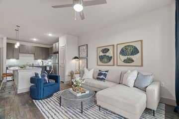 Kyle apartment for rent - A living room with a blue chair and a white couch.