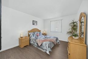 Tucson apartment for rent - A bedroom with a bed, nightstand, and a plant.