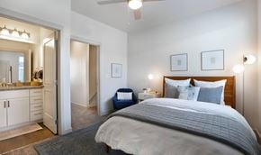 Salt Lake City apartment for rent - A bedroom with a large bed and a vanity with a mirror.