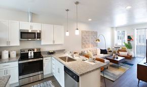 Salt Lake City apartment for rent - A modern kitchen with white cabinets and stainless steel appliances.