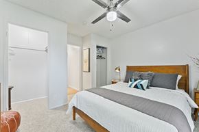 Reno apartment for rent - A bedroom with a bed, a ceiling fan, and a chair.