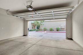 Tucson apartment for rent - A large, empty garage with a view of a parking lot and a building outside.