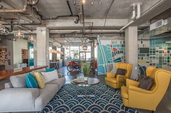 A modern living room with a grey couch, yellow chairs