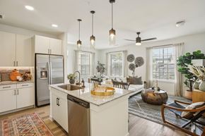 Manor apartment for rent - A kitchen with a refrigerator, sink, and a dining table with chairs.