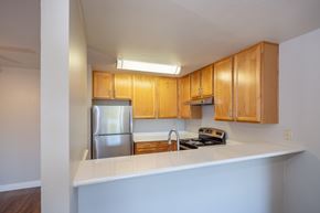 Pleasant Hill apartment for rent - A kitchen with wooden cabinets and a stainless steel refrigerator.