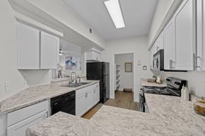 Gilbert apartment for rent - A kitchen with white cabinets and a marble countertop.