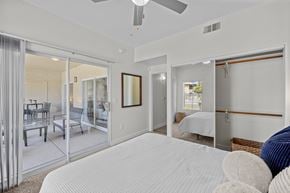 Gilbert apartment for rent - A bedroom with a large bed and a sliding glass door leading to a balcony.