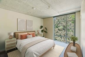 Portland apartment for rent - Bedroom with large windows looking at nature and trees at 2121 Belmont apartments in the Buckman neighborhood in Portland, Oregon.