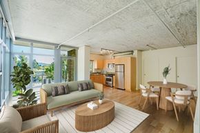 Portland apartment for rent - Living room with large windows and wood-style flooring at 2121 Belmont apartments in the Buckman neighborhood in Portland, Oregon.