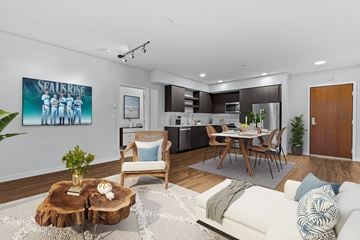 Bainbridge apartment for rent - A modern living room with a wooden coffee table and a painting of a group of people.