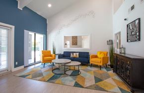 Tucson apartment for rent - A living room with a blue couch, yellow chairs, and a colorful rug.