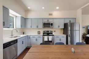 Tucson apartment for rent - A kitchen with a wooden table in front of it.