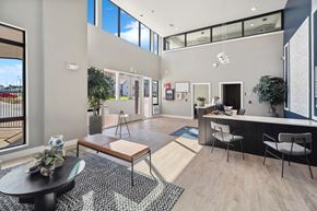 Denver apartment for rent - A modern office space with a black and white rug, a wooden table, and a glass wall.
