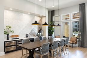 Magnolia apartment for rent - a kitchen with a long wooden table and chairs