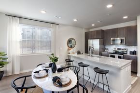 Spring apartment for rent - an open kitchen and dining area with a marble counter top and a table with chairs