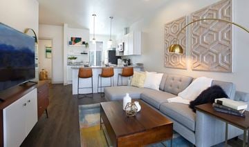Salt Lake City apartment for rent - A modern living room with a grey couch and a wooden coffee table.