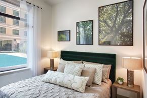 Denver apartment for rent - A bedroom with a large bed and a green headboard.