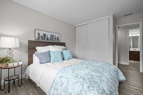 Fair Oaks apartment for rent - A bedroom with a bed covered in a blue and white patterned duvet.