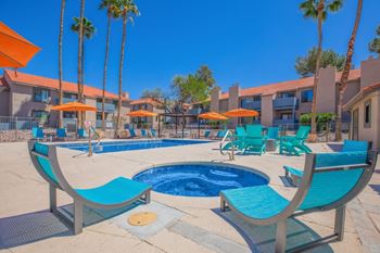 Pool deck with hot tub and lounge chairs
