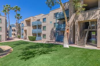 Apartment courtyard with green lawn and palm trees