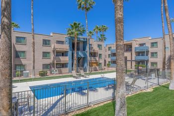 Swimming pool area with palm trees and apartment buildings