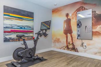 Home gym with exercise bike and wall art