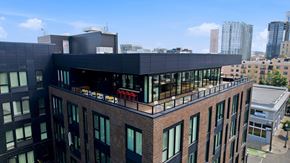 Portland apartment for rent - A modern building with a black facade stands out against the city skyline.