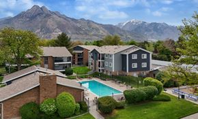 Holladay apartment for rent - A large house with a pool and mountains in the background.