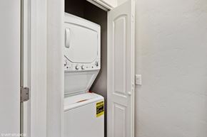 Tucson apartment for rent - A white fridge is in a narrow space between a door and a wall.