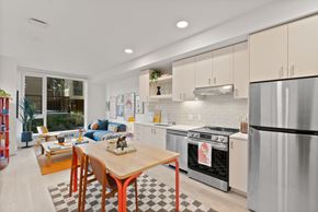 Bend apartment for rent - A modern kitchen with a wooden table and stainless steel appliances.