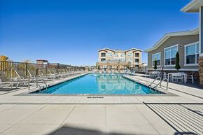 Denver apartment for rent - A swimming pool surrounded by lounge chairs and apartment buildings.