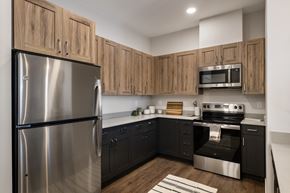 Kennewick apartment for rent - A modern kitchen with wooden cabinets and stainless steel appliances.