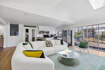 Tacoma apartment for rent - A modern living room with a white couch and a glass table.