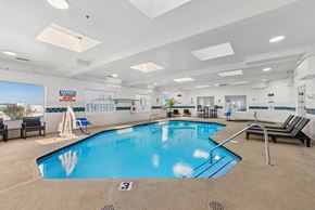 Kennewick apartment for rent - Indoor swimming pool with skylights and lounge chairs at The Q Apartments, Kennewick, WA 99336