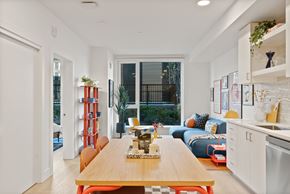 Bend apartment for rent - A modern kitchen with a wooden table and orange chairs.