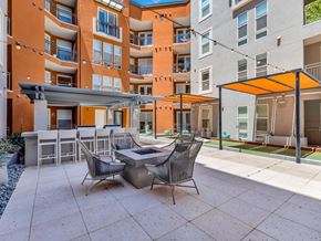 Las Vegas apartment for rent - A patio with a table and chairs is in front of a building.