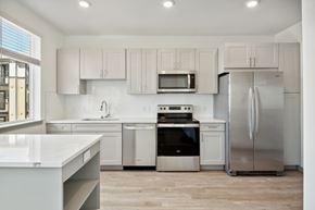 Denver apartment for rent - A modern kitchen with stainless steel appliances and white cabinets.