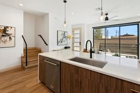 Phoenix apartment for rent - A modern kitchen with wooden cabinets and a stainless steel dishwasher.