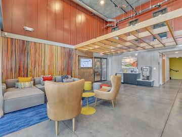 Las Vegas apartment for rent - A modern living room with a grey sofa, yellow chairs and a striped wallpaper.