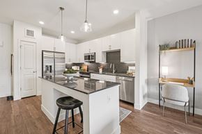 Denver apartment for rent - A modern kitchen with a white island and stools.