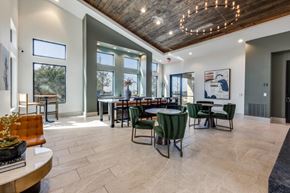 Austin apartment for rent - A modern dining room with a wooden ceiling and a large table surrounded by chairs.